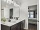 Modern bathroom with double sinks, black hardware, vanity lighting, and a view into a primary bedroom at 1441 Arabella St, Charleston, SC 29414