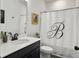 Clean bathroom with modern fixtures, white countertops, black hardware, and a decorative shower curtain at 1441 Arabella St, Charleston, SC 29414
