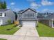 Charming two-story home with a well-manicured lawn and a two-car garage on a sunny day at 1441 Arabella St, Charleston, SC 29414