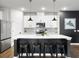 Stylish kitchen island with seating, modern lighting, and white cabinetry, complemented by sleek countertops at 1441 Arabella St, Charleston, SC 29414