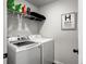 Functional laundry room with modern washer and dryer, plus shelving for storage at 1441 Arabella St, Charleston, SC 29414