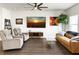 Relax in this living room with cozy seating, stylish decor, a ceiling fan, and attractive flooring at 1441 Arabella St, Charleston, SC 29414