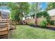 Large backyard with grass, wood fence, brick firepit, and wood deck with steps in a residential neighborhood at 15 Dewey St, Charleston, SC 29403