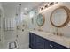 Bathroom featuring double sinks, mirrors, vanity, glass shower, and decorative tile floors at 15 Dewey St, Charleston, SC 29403