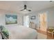 Cozy bedroom with a white bed, ceiling fan, dresser, wall-mounted TV, and doorway to a bathroom at 15 Dewey St, Charleston, SC 29403