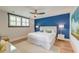 Bedroom featuring a white bed, nightstands with lamps, blue accent wall, ceiling fan, and light-colored floors at 15 Dewey St, Charleston, SC 29403