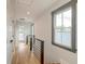 Bright hallway with natural light, hardwood floors, modern railings, and doors to other rooms at 15 Dewey St, Charleston, SC 29403