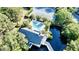 Aerial view of a home with a pool and tennis court, all surrounded by trees and next to a river at 1551 Ben Sawyer Blvd # 23, Mount Pleasant, SC 29464