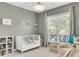Cozy bedroom featuring a crib, a large window, and ample natural light at 1572 Pixley St, Charleston, SC 29414