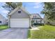 Home featuring a two-car garage, a well-manicured lawn, and classic exterior shutters at 1572 Pixley St, Charleston, SC 29414
