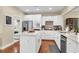 Modern white kitchen with stainless steel appliances, an island with granite countertops, and wood flooring at 1572 Pixley St, Charleston, SC 29414