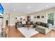 Cozy living room with large sectional, white rug, hardwood floors, and views into the kitchen at 1572 Pixley St, Charleston, SC 29414