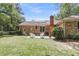 Brick home backyard featuring a patio with outdoor seating and a well-maintained lawn at 1705 Sulgrave Rd, Charleston, SC 29414