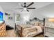 Bright bedroom with wood floors, ceiling fan, large bed with many pillows and adjacent side table at 1705 Sulgrave Rd, Charleston, SC 29414