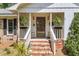 Cozy front porch with rocking chairs, decorative plants, brick stairs, and charming curb appeal at 1705 Sulgrave Rd, Charleston, SC 29414