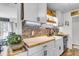 Updated kitchen features butcher block counters, white cabinetry, brick backsplash, and stainless steel appliances at 1705 Sulgrave Rd, Charleston, SC 29414
