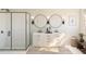 Elegant bathroom with a glass-enclosed shower, double vanity, round mirrors, and neutral color palette at 2034 Mcguire Ln # 009, Hollywood, SC 29449