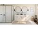 Elegant bathroom with dual sinks, round mirrors, a walk-in shower with white tiling, and modern fixtures at 2038 Mcguire Ln # 010, Hollywood, SC 29449