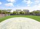 Manicured backyard with a circular patio area, green lawn, and dark wooden fencing at 204 Lynx Ln, Summerville, SC 29483