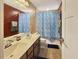 Bathroom with double sinks, large mirror, and shower with blue patterned curtain at 204 Lynx Ln, Summerville, SC 29483
