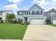 Charming two-story home with a well-manicured lawn, a two-car garage, and a blue facade at 204 Lynx Ln, Summerville, SC 29483