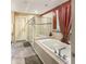 Luxurious main bathroom with a large soaking tub, glass-enclosed shower, and modern fixtures at 204 Lynx Ln, Summerville, SC 29483