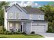 Charming two-story home featuring a covered porch, two-car garage, and manicured lawn at 206 Belfort Way, Summerville, SC 29486
