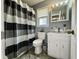 Well-lit bathroom features a vanity with sink, mirror, toilet, and striped shower curtain at 207 Longstreet St, Summerville, SC 29486