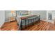 Relax in this cozy bedroom featuring hardwood floors, a black iron bed frame, and soothing blue bedding at 208 Sea Cloud Cir, Edisto Island, SC 29438
