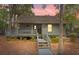 Charming coastal home with elevated porch and walkway surrounded by lush landscaping and trees at 208 Sea Cloud Cir, Edisto Island, SC 29438