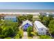 Aerial view of a colorful neighborhood, showcasing a purple home and its proximity to the sandy beach and ocean at 220 E Arctic Ave, Folly Beach, SC 29439