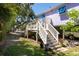 Backyard features stairs, mature trees, and a glimpse of the neighborhood, offering a tranquil outdoor space at 220 E Arctic Ave, Folly Beach, SC 29439