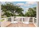 Outdoor balcony showcasing outdoor seating with views of surrounding trees and neighborhood homes at 220 E Arctic Ave, Folly Beach, SC 29439