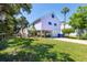 Charming exterior of a purple stilt home with a lush green lawn and convenient driveway leading to under-house parking at 220 E Arctic Ave, Folly Beach, SC 29439