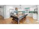 Modern kitchen featuring a large island dining table, with sleek white cabinets, stainless steel appliances at 220 E Arctic Ave, Folly Beach, SC 29439