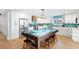 Gourmet kitchen features a pool table as a centerpiece, white cabinetry, and a unique wood range hood at 220 E Arctic Ave, Folly Beach, SC 29439