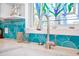 Close-up of a kitchen faucet with turquoise tile backsplash and decorative stained-glass window at 220 E Arctic Ave, Folly Beach, SC 29439