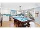 Open-concept kitchen featuring a pool table as a centerpiece, white cabinetry, and stainless steel appliances at 220 E Arctic Ave, Folly Beach, SC 29439