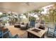 Inviting screened porch features cozy seating, ceiling fans, and a charming fire pit, perfect for relaxation at 220 E Arctic Ave, Folly Beach, SC 29439