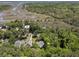 Aerial view of homes surrounded by trees and wetlands with a waterway in the distance at 3021 Rushland Mews, Johns Island, SC 29455