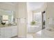 Beautiful bathroom featuring double sinks and a soaking tub under a glass block window at 3021 Rushland Mews, Johns Island, SC 29455
