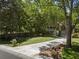 Front yard featuring a manicured lawn, mature trees, and a paved driveway at 3021 Rushland Mews, Johns Island, SC 29455