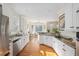 Well-lit kitchen featuring granite countertops, white cabinets, stainless steel appliances, and hardwood floors at 3021 Rushland Mews, Johns Island, SC 29455