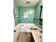 Charming half bathroom with teal walls, white wainscoting, and wood-look tile floors at 303 Seneca River Dr, Summerville, SC 29485