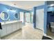 A blue bathroom features a double sink vanity, a tub with shower, and a white door to the toilet at 303 Seneca River Dr, Summerville, SC 29485
