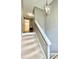 Carpeted stairway with white railings and a view to a bathroom on the second level at 303 Seneca River Dr, Summerville, SC 29485