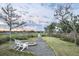 Inviting backyard featuring a fire pit, Adirondack chairs and a path to a private dock at 314 Commonwealth Rd, Mount Pleasant, SC 29466