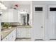Bright bathroom featuring double sinks with granite countertops, white cabinets, and stylish fixtures at 314 Commonwealth Rd, Mount Pleasant, SC 29466