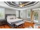 Spacious main bedroom boasts a tray ceiling, ceiling fan, and balcony access with plenty of natural light at 314 Commonwealth Rd, Mount Pleasant, SC 29466