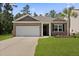Charming brick home with a two-car garage, manicured lawn, and mature landscaping at 318 Bering Ln, Summerville, SC 29486